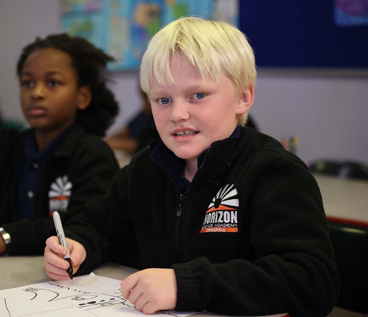 Horizon Science Academy Springfield student wearing headphones uses a laptop in class